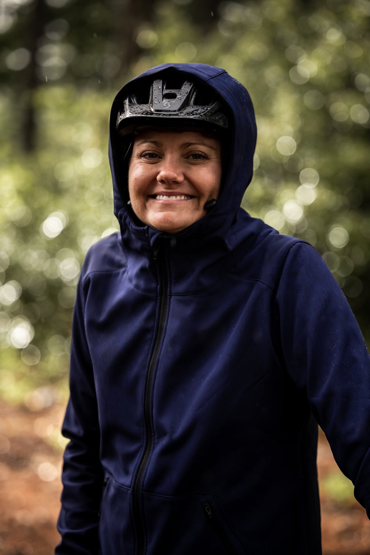 Rider outdoors wearing the navy Softshell Jacket with hood over a helmet